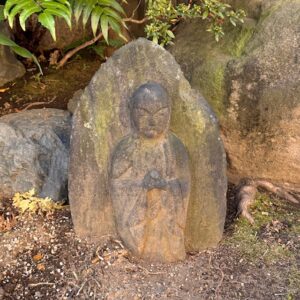 Statue de Jizō à l’entrée du temple Chōmeiji à Yanaka (Tokyo), près du lieu où se trouve Ebisu du parcours des Sept Dieux du Bonheur.